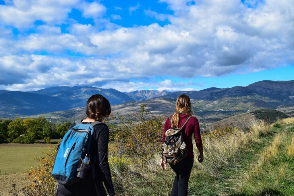 duas mulheres caminhando em uma área gramada