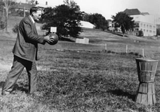 James Naismith com uma bola de basquete nas mãos